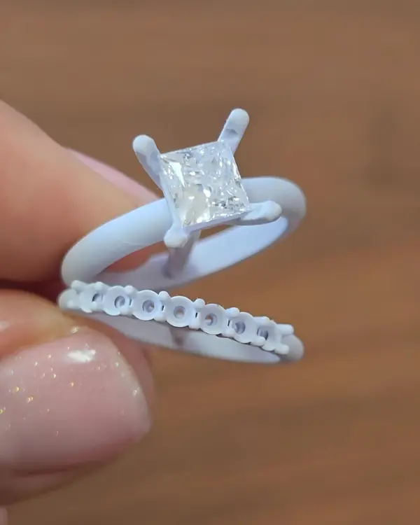 Modelo 3D impreso del anillo y su argolla, con el diamante montado, sostenido en la mano